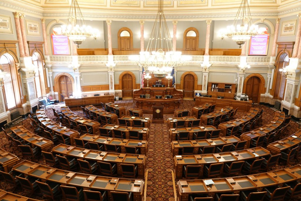 pexels photo 10209717 10209717 Wide view of an ornate legislative chamber with empty seats and chandeliers.